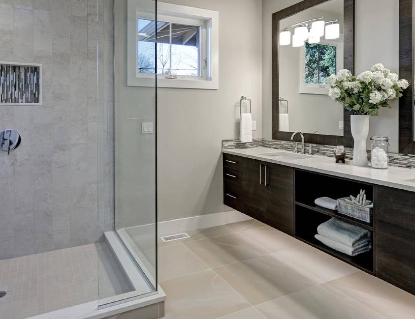 Modern bathroom with walk-in shower, double vanity, and decorative flowers