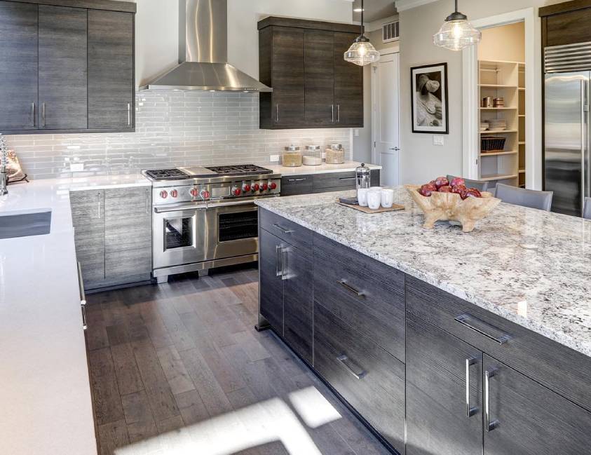 Modern kitchen with dark cabinets, stainless steel appliances, and a central island