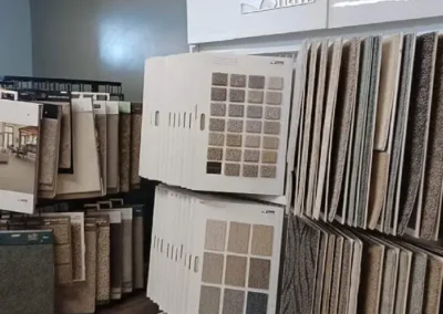 Display of various carpet samples in a showroom with the Shaw brand sign